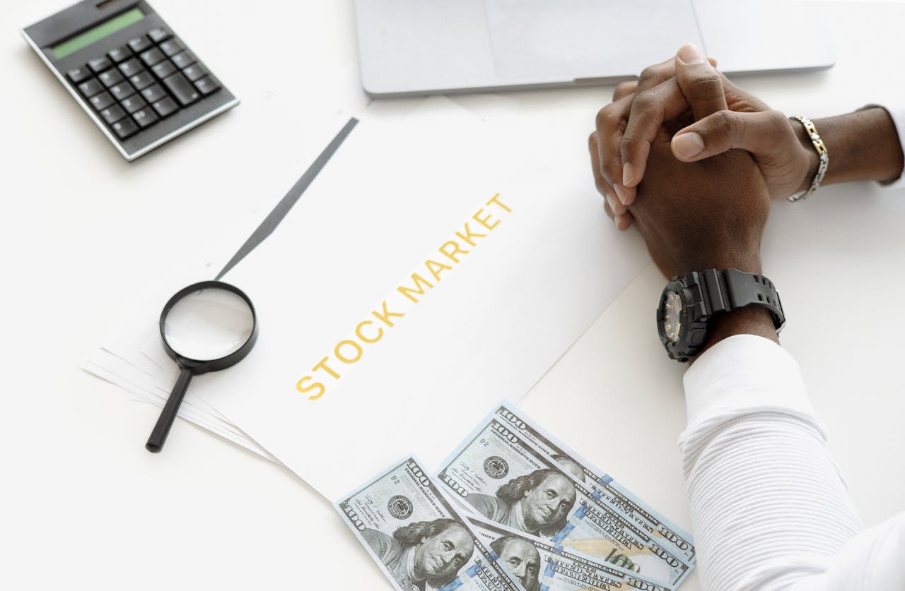 Crafting Captivating Headlines: Your awesome post title goes here Hands folded over stock market documents with calculator and cash on desk.